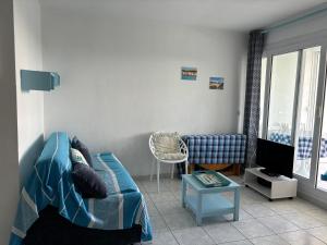 un soggiorno con divano e TV di Appartement classé, vue mer, clim, wifi, parking a La Grande-Motte