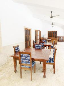 uma sala de jantar com uma mesa de madeira e cadeiras em VILLA GUAVABERRY n em Paraíso