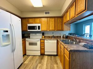 a kitchen with white appliances and wooden cabinets at Celebrity Inn in Branson