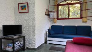 a living room with a blue couch and a window at Chalé Vermelho - Sítio Caldeirão in Araras Petropolis
