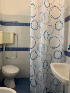 uma casa de banho com um WC e uma cortina de chuveiro em Hotel Garni Picnic em Riccione