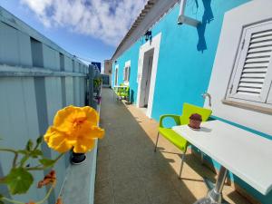 een blauw gebouw met een gele bloem in een vaas bij Ibiza Suite Independent bedroom and bathroom in Albufeira