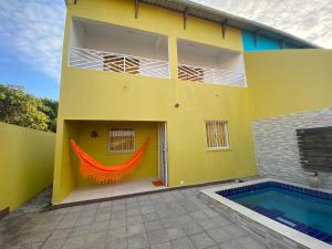 a yellow house with a swimming pool in front of it at Linda Casa com piscina Brisa do Mar - Maragogi in Maragogi
