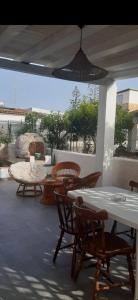 a patio with chairs and tables and a pendant light at Villa Salvina Beach in Fontane Bianche