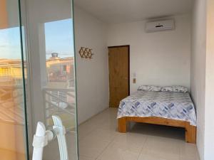 a bedroom with a bed and a glass door at Linda Casa com piscina Brisa do Mar - Maragogi in Maragogi +22 photos