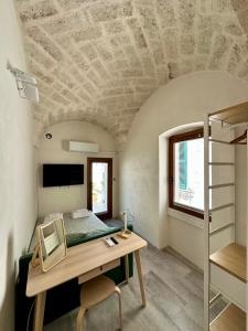 a room with a desk and a bed and a ladder at Tangram Ostuni Apartment in Ostuni +11 photos