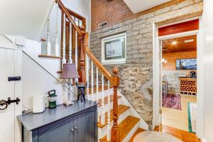 a staircase in a home with a stone wall at Downtown Essex Apartment - Steps to River! in Essex