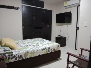 een slaapkamer met een bed en een flatscreen-tv bij Confortable Aparta Estudio al Norte in Neiva