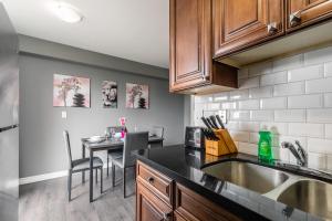 a kitchen with a sink and a table with chairs at 2BR Apt - Near Downtown Hamilton - Sleeps 6 in Hamilton