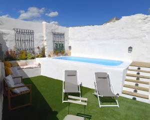 a patio with two chairs and a swimming pool at Casa Rural La Rosquilla in Mandayona