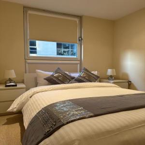 Un dormitorio con una cama grande y una ventana en Canary Wharf - Luxury Apartments, en Londres