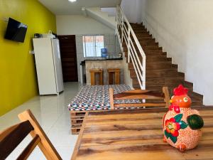 a living room with a staircase and a refrigerator at Linda Casa com piscina Brisa do Mar - Maragogi in Maragogi