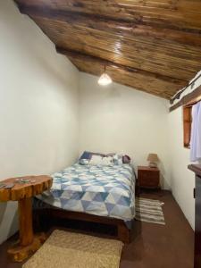 um quarto com uma cama e um tecto de madeira em Casita Hierbabuena em Ibarra