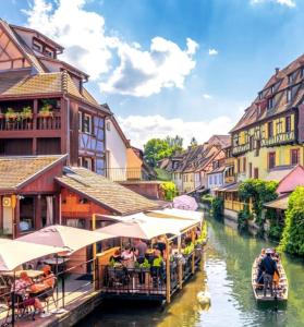a group of people riding boats down a river at Maison des mésanges in Colmar