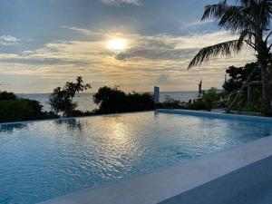 a large swimming pool with the ocean in the background at WissaHomeZanzibar in Dambani
