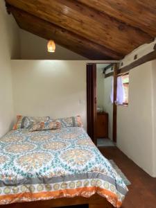 a bedroom with a bed and a wooden ceiling at Casita Hierbabuena in Ibarra