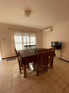 サン・ラファエルにあるCabañas El Rosal departamentoのテーブルと椅子とテレビのあるダイニングルーム