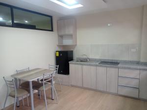 a kitchen with a table and a sink and a refrigerator at Rossy House in Baños
