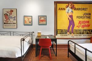 a bedroom with a bed and a desk and a movie poster at Chelsea Pines Inn in New York