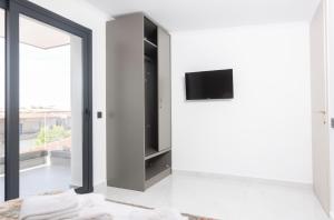a living room with a tv on a wall at Victory VIP apartments in Kallithea Halkidikis