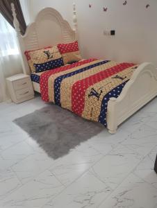 a bedroom with a bed and a white tiled floor at Emerald Crest in Tamale