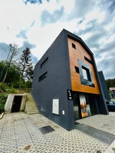 a building on a cobblestone street next to a parking lot at Eliška apartment - modern mountain loft apartment in Ski resort Malino Brdo in Ružomberok