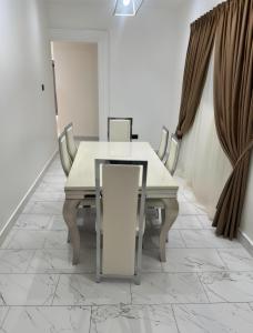 a dining room with a white table and chairs at Emerald Crest in Tamale