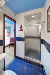 a bathroom with a shower with blue tiles at Chelsea Pines Inn in New York