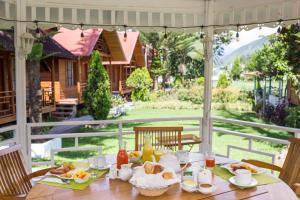 a table with food and a view of a house at Cemayu Lodge in Oxapampa