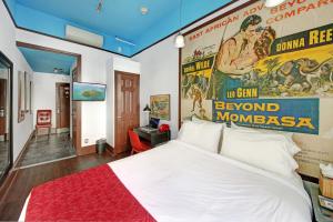a bedroom with a large bed with a poster on the wall at Chelsea Pines Inn in New York