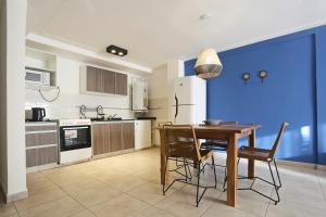 a kitchen with a table and chairs and a blue wall at Cipres 4 B in San Miguel de Tucumán