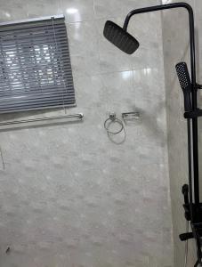 a shower with a shower head in a bathroom at Emerald Crest in Tamale