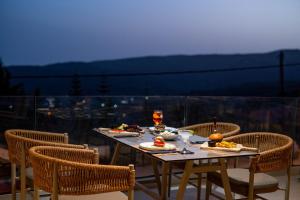 una mesa con platos de comida, bebidas y sillas en Maria Resort Parga en Parga