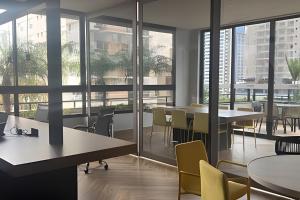 un ufficio con tavoli, sedie e ampie finestre di Lar no Bueno/ Apto. de Luxo 2 quartos a Goiânia