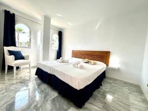 Diletta Beach Estepona في إِستيبونا: غرفة نوم بسرير كبير وكرسي