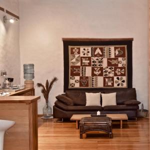 Una sala de estar con un sofá de cuero y una mesa. en Wantara Suites, en Quito