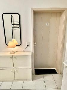 a bathroom with a mirror and a door with a lamp at Hotel Garni Am Schäfersberg in Niedernhausen