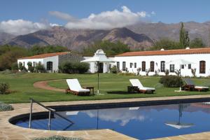 a house with a swimming pool in front of a building at Patios de Cafayate - Wine Hotel & Restaurant in Cafayate