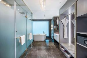 uma casa de banho com uma banheira e um lavatório em Radisson Blu Hotel GRT, Chennai International Airport em Chennai