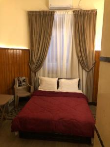a bedroom with a red bed with a window at Centro Citta Hotel in Cairo