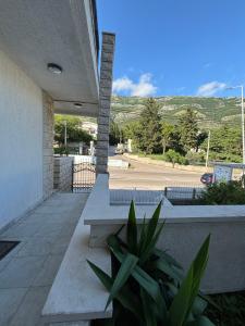 a porch with two benches and a view of a street at Villa Mia apartments in Sutomore