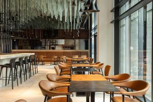 突尼斯Radisson Hotel Tunis, City Center的有木桌椅和枝形吊灯的餐厅