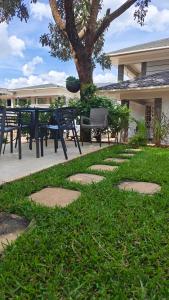 Annavilla7 Lilongwe Aparthotel في ليلونغوي: حديقة بها طاولات وكراسي وشجرة