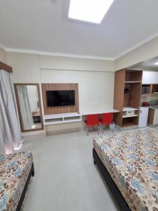 ein Hotelzimmer mit 2 Betten und einem TV in der Unterkunft Spazzio diRoma RM Hospedagem com Acesso Acqua Park/Splash in Caldas Novas