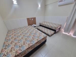 2 Betten in einem kleinen Zimmer mit in der Unterkunft Spazzio diRoma RM Hospedagem com Acesso Acqua Park/Splash in Caldas Novas