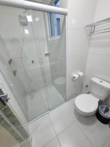 La salle de bains blanche est pourvue d'une douche et de toilettes. dans l'établissement Spazzio diRoma RM Hospedagem com Acesso Acqua Park/Splash, à Caldas Novas