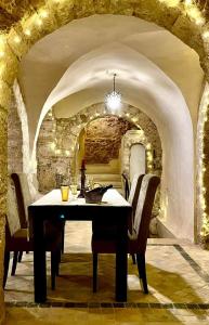 - une salle à manger avec une table et des chaises dans une voûte dans l'établissement Dar Aziz, à Sousse