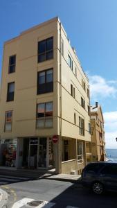 a tall building with a car parked in front of it at VRS - PORTO BEACH FLAT in Porto