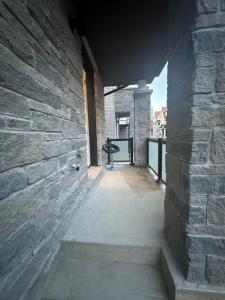 un pasillo vacío con una pared de ladrillo y una escalera en Keppel Circle Residence en Brampton