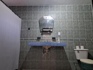 a bathroom with a blue sink and a toilet at Aurora in Cancún